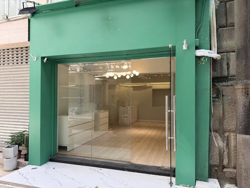 Shop on Circular Pathway, Sheung Wan. Storefront with green frame, glass doors, and an empty interior with a circular pathway.