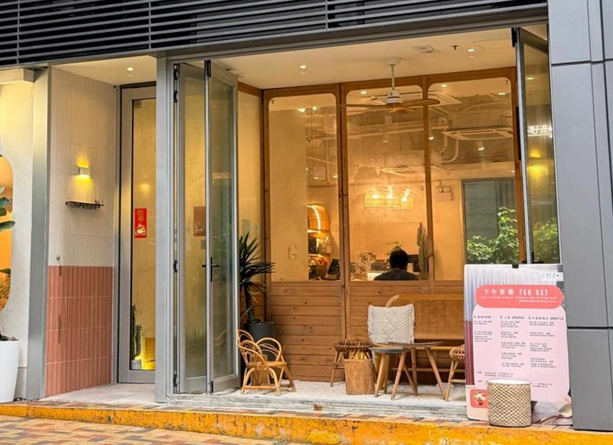 西營盤一家現代咖啡店設有玻璃門、木製椅子及室內盆栽。