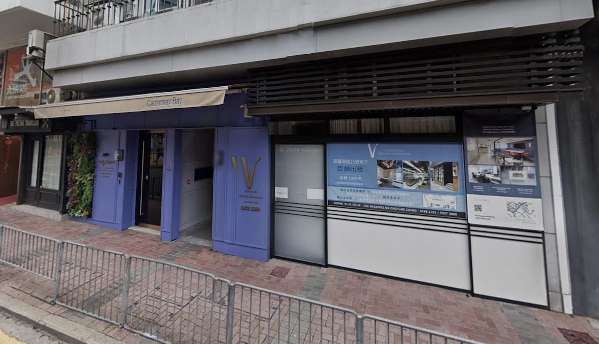 Storefront on Tung Lo Wan Road with blue and white signage, glass doors, and posters in Chinese visible from the street.