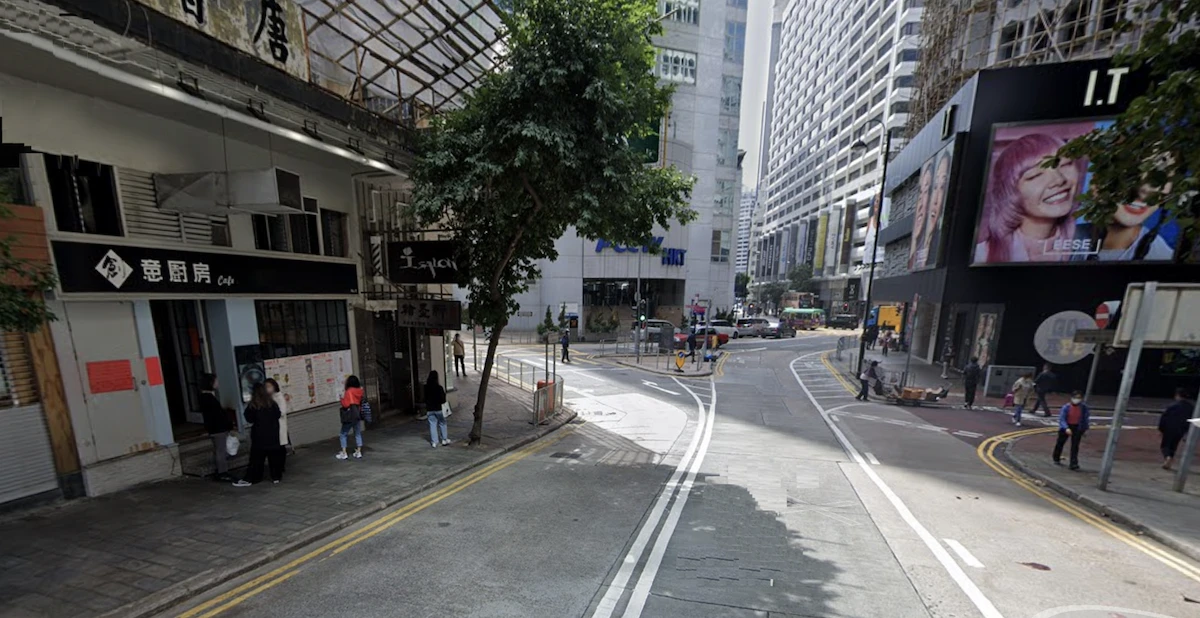 銅鑼灣街道兩旁樓宇林立,設有商業招牌及行道樹,行人往來。