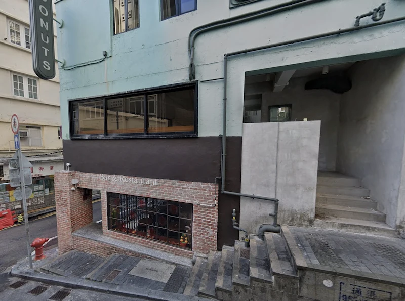 中環餐廳舖位。伊利近街一幢兩層磚砌建築設大型窗戶，戶外樓梯通往側門。