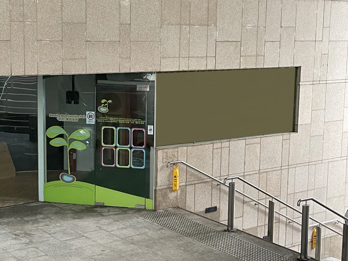 Glass doors with a tree design near First Street in Sai Ying Pun and a wet floor sign on the stair railing.
