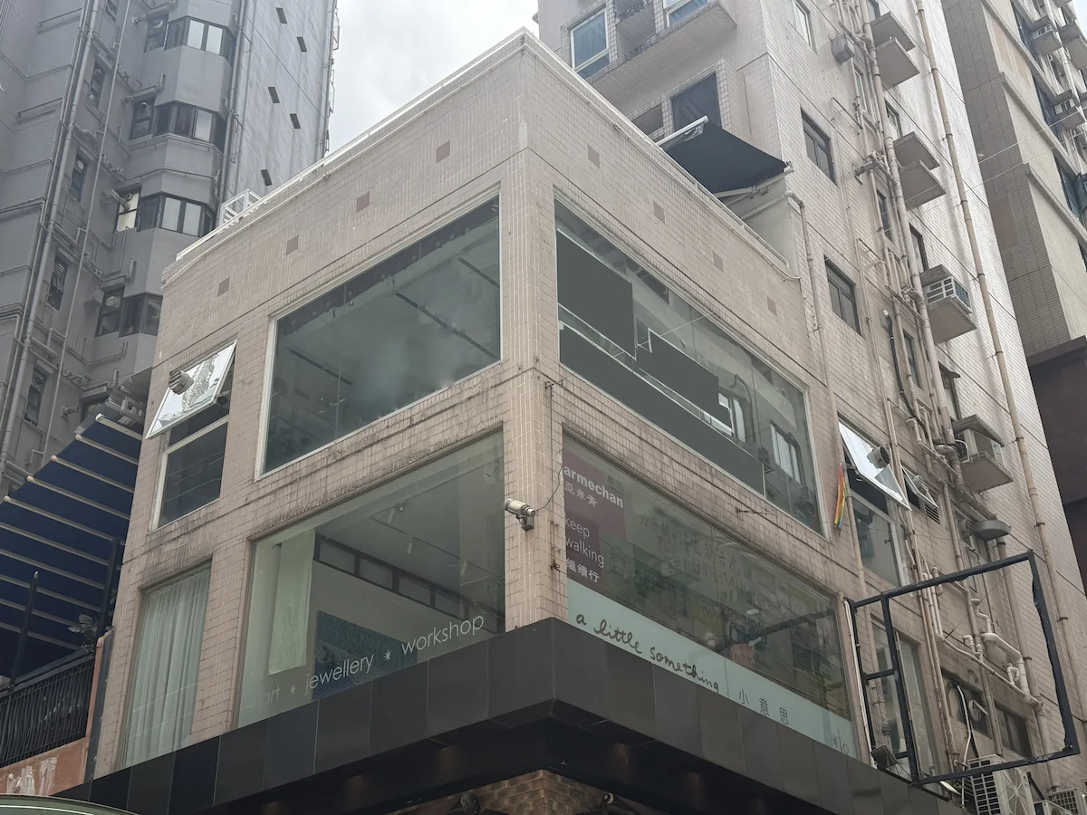 Beige building on the corner of Staunton Street, Central, with large glass windows and a rainbow flag displayed outside.