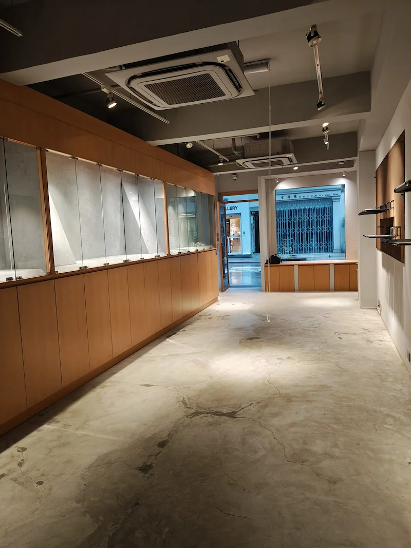 Shop on Hollywood Road, Sheung Wan. Empty store interior featuring glass display cases, wooden cabinets, and Sheung Wan visible outside.