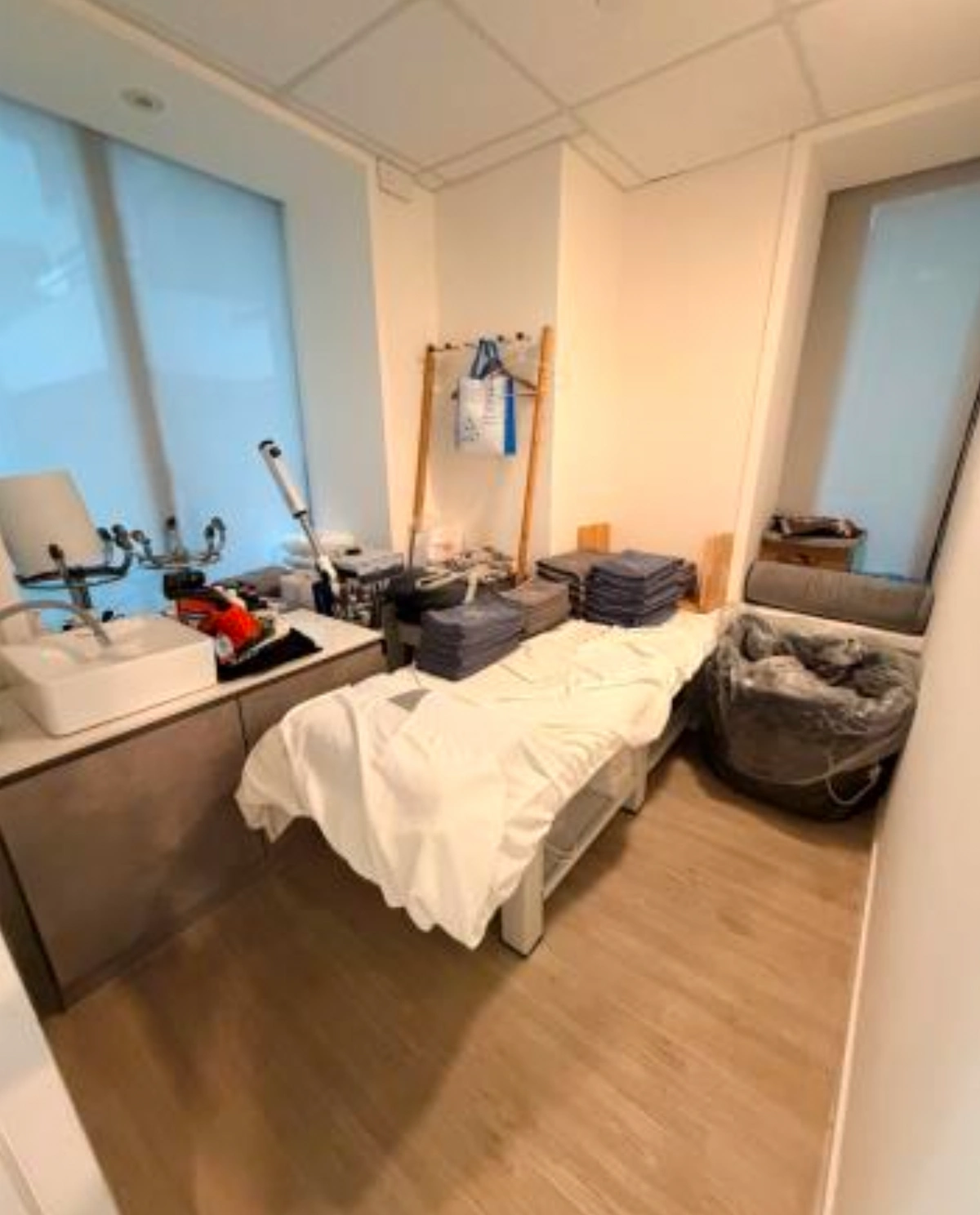 Clinic room on D’Aguilar Street, Central, featuring a treatment bed, folded towels, and various medical equipment.