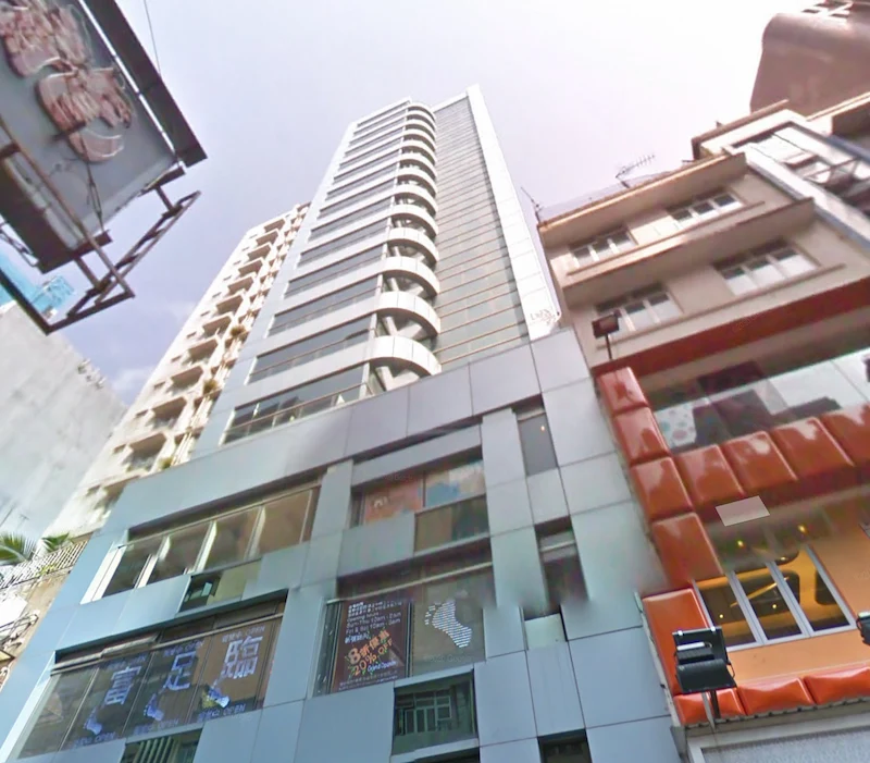 Shop on Granville Road, Sheung Wan. Glass-windowed modern building, surrounded by older buildings, viewed from the street on a sunny day.