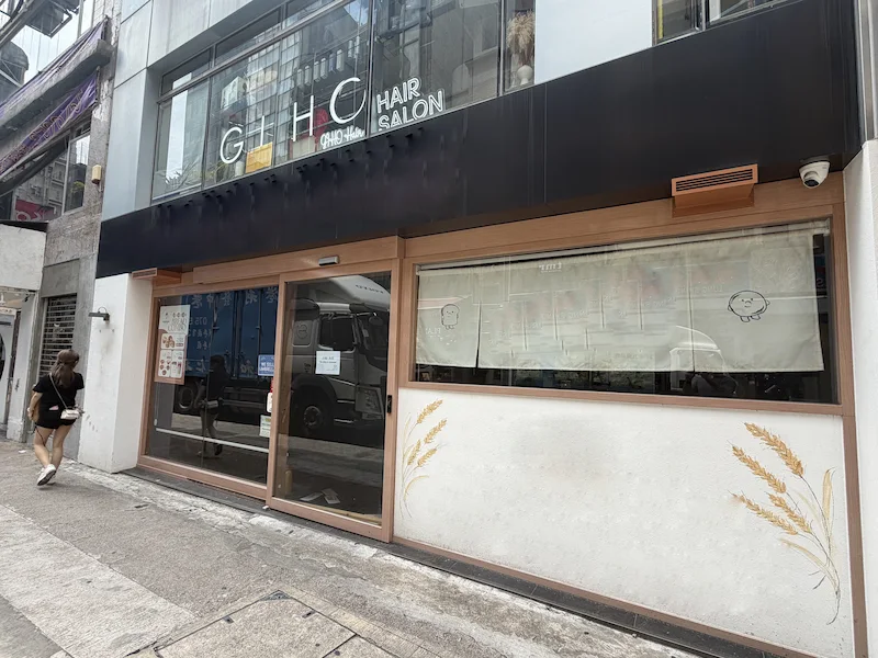 Restaurant space on Granville Road, Tsim Sha Tsui. Closed shopfront with wheat designs, with a person walking past curtained windows.