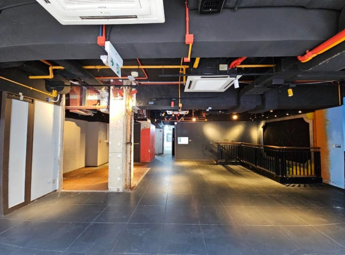 Empty industrial-style room near Granville Road with tiled floor and a black railing walkway on the right side.