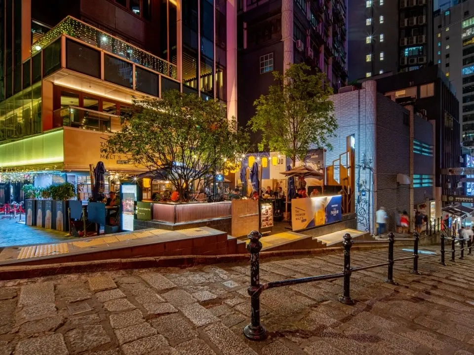 中環餐廳舖位。砵典乍街入夜後可見鵝卵石斜路、多間咖啡店、戶外座位及高樓大廈。