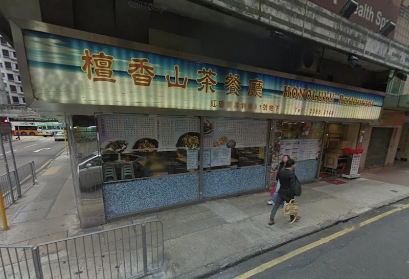 Shop on Bulkeley Street, Hung Hom. Honolulu Restaurant with Chinese and English signs visible, pedestrian walking past the entrance.