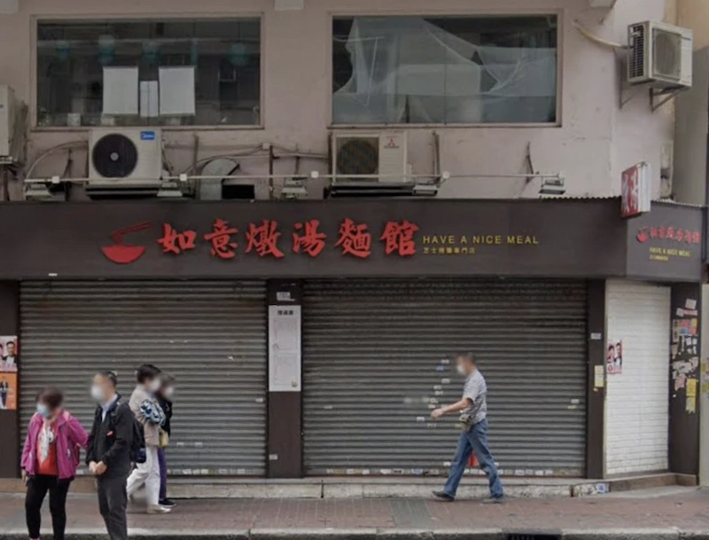 Shop on Portland Street, Mong Kok. Four people pass a closed restaurant, under a sign reading HAVE A NICE MEAL.