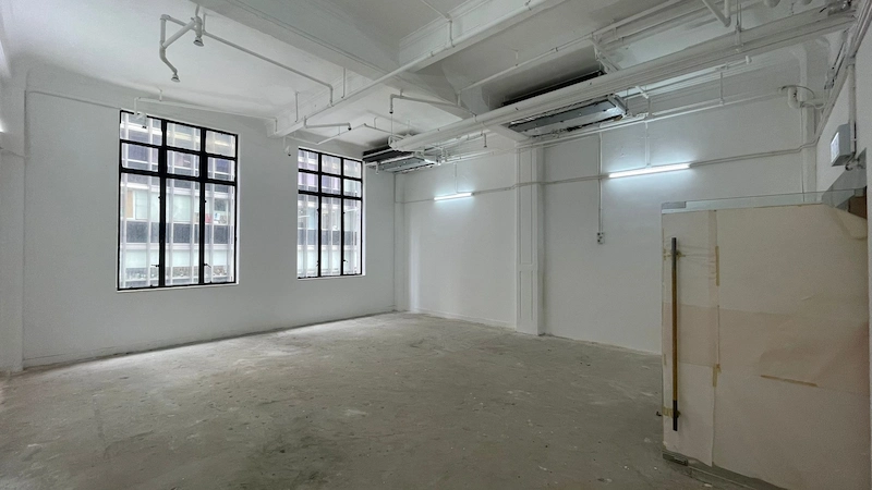 Office on Pedder Street, Central. Unfurnished room Central with white walls, ceiling pipes, two windows, and a covered object.
