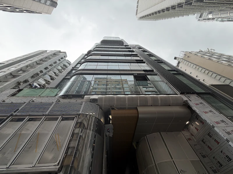 尖沙咀餐廳舖位。金巴利道一幢玻璃高樓仰視所見，鄰近為其他高樓，天空多雲。