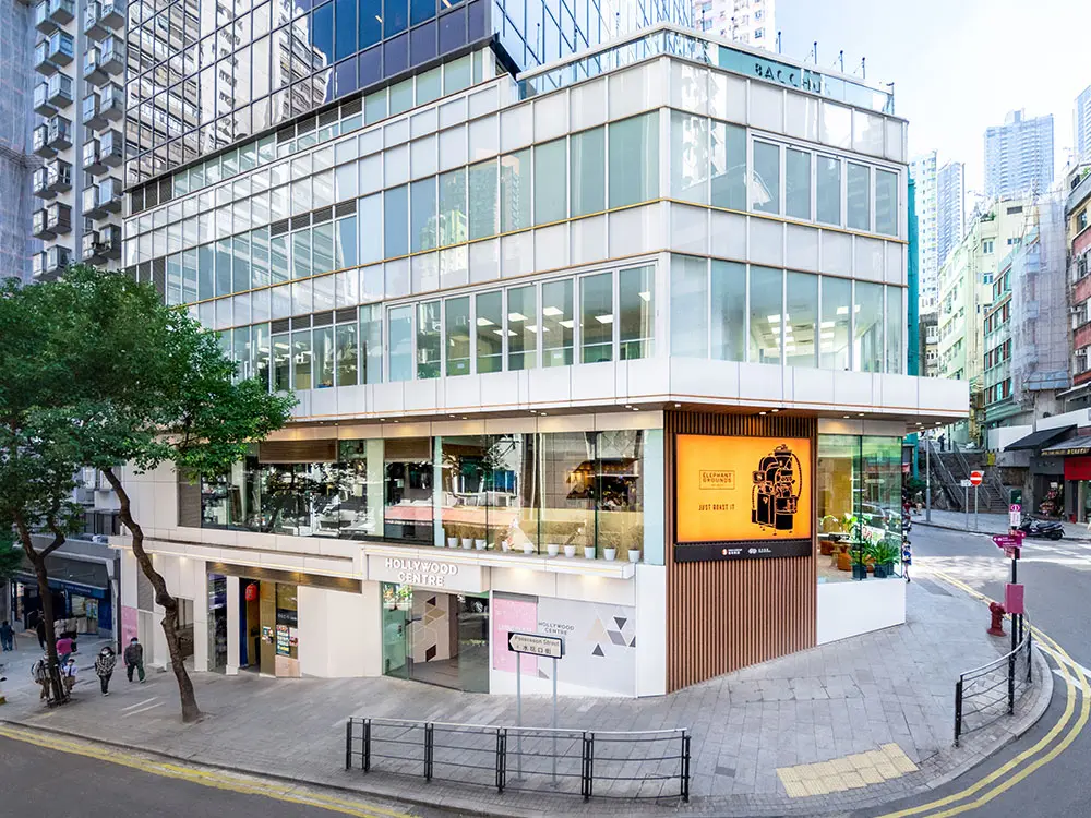 Shop on Hollywood Road, Sheung Wan. Glass building with shops at street level, offices above, and surrounded by tall buildings.