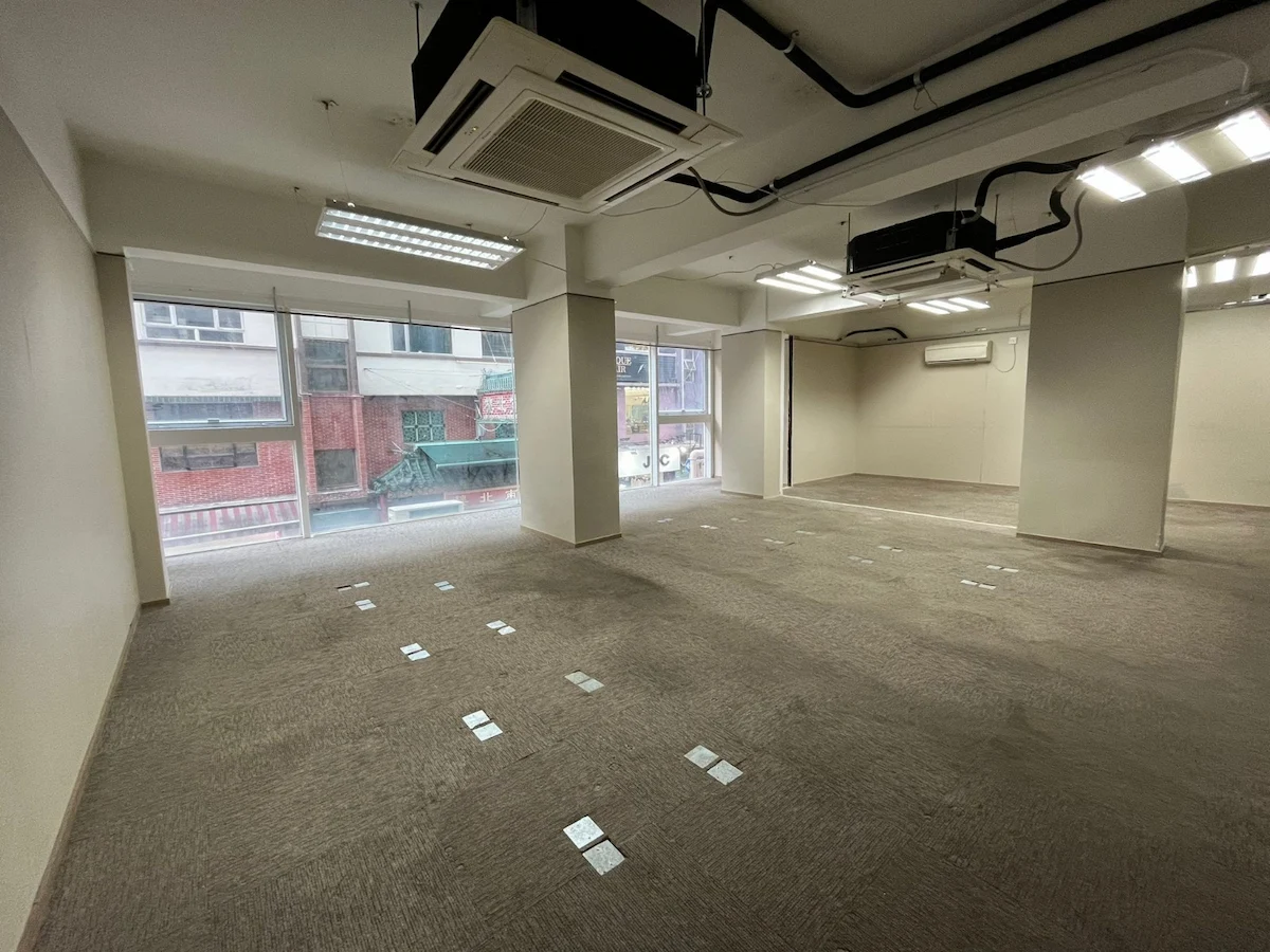 Office space on Lan Fong Road in Causeway Bay with carpeted floors, large windows, and exposed ceiling ducts.