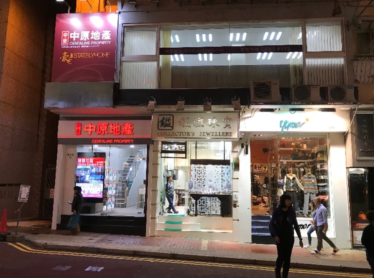 Night street view of three illuminated storefronts on Lan Fong Road in Causeway Bay, one is a jewelry shop.