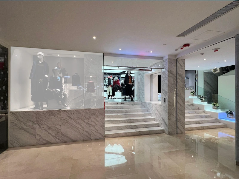 Shop on Great George Street, Causeway Bay. Retail space, with marble floors, window mannequins, stairs, and clothing racks.