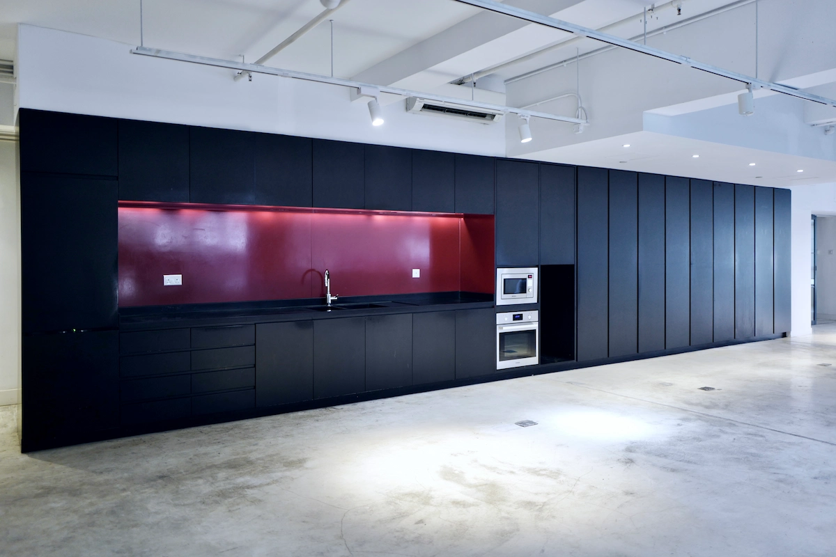 Kitchen in Sheung Wan with matte black cabinets, red backsplash, built-in storage, and under-counter sink.