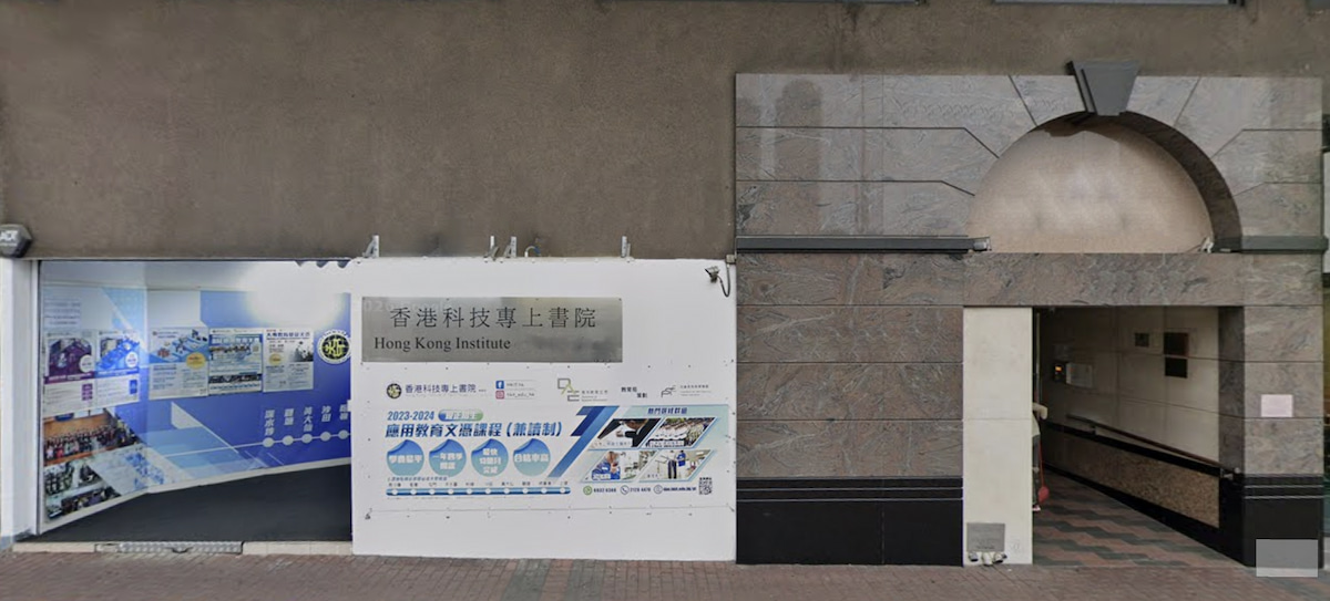 Entrance to the Hong Kong Institute with signs, posters, and a stone archway along Cheung Sha Wan Road sidewalk.