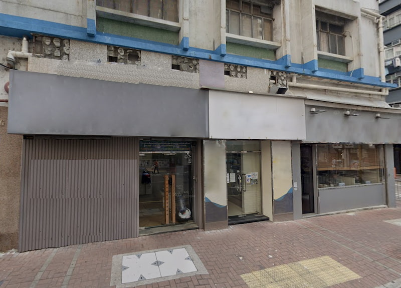 Shop on Bulkeley Street, Hung Hom. Closed storefront Hung Hom with blank sign above glass doors and tiled sidewalk in front.