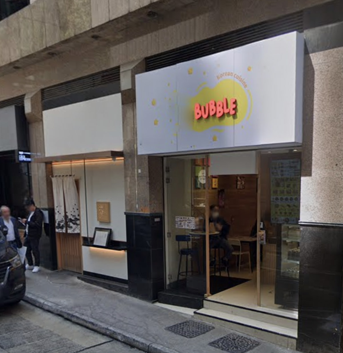 Street view of a bubble tea shop on Stanley Street Central with a Bubble sign and glass doors at the entrance.