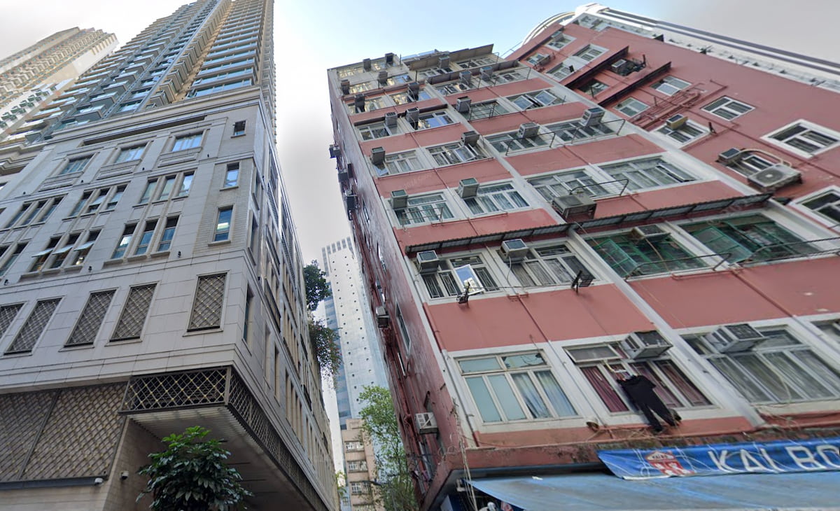 Two tall buildings are side by side on Spring Garden Lane, Wan Chai, under a partly cloudy sky.