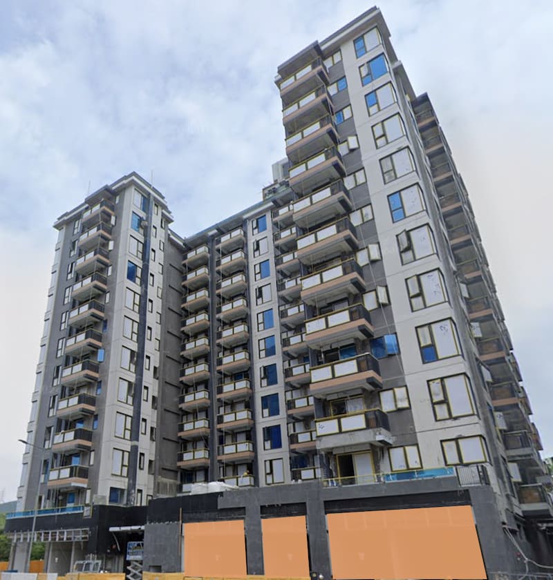 Shop on Hung On Lane, Yuen Long. Modern multi-story apartment building with balconies and large windows under cloudy sky.