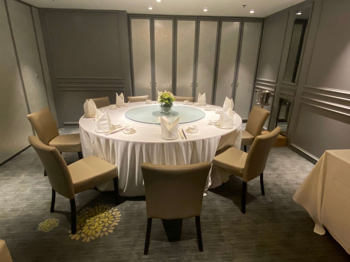 軒尼詩道一張圓形餐桌配八張椅子，鋪白色枱布，設餐具及花卉擺設。