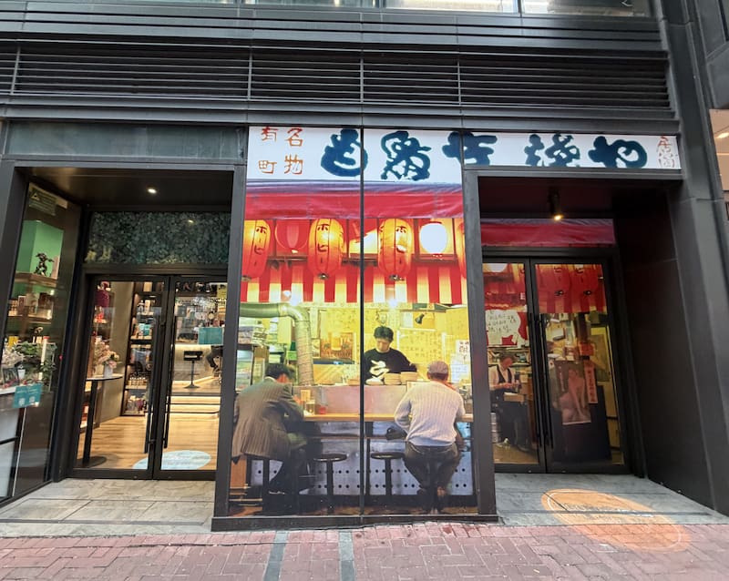 Shop on Bailey Street, Hung Hom. Storefront with glass doors, Chinese signs, and a mural showing people dining inside.