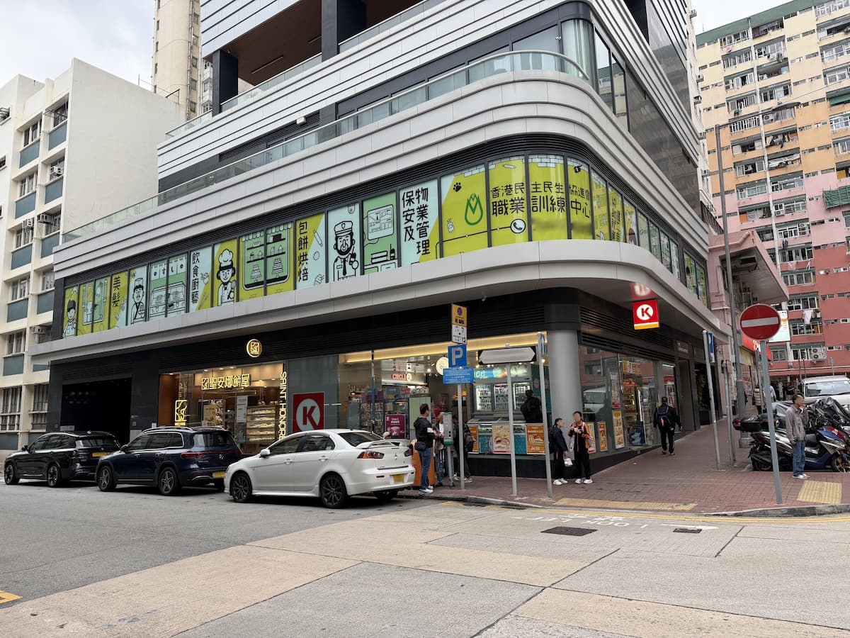 Circle K on Maidstone Road, To Kwa Wan, seen from the street with parked cars and people walking outside.