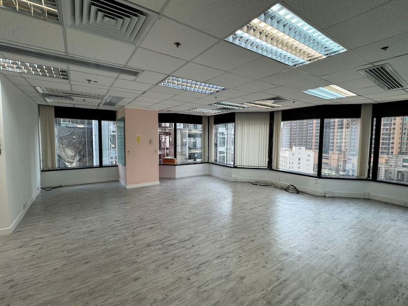 Office on Leighton Road, Causeway Bay. Empty office room with large windows, light wood floors, and city views.