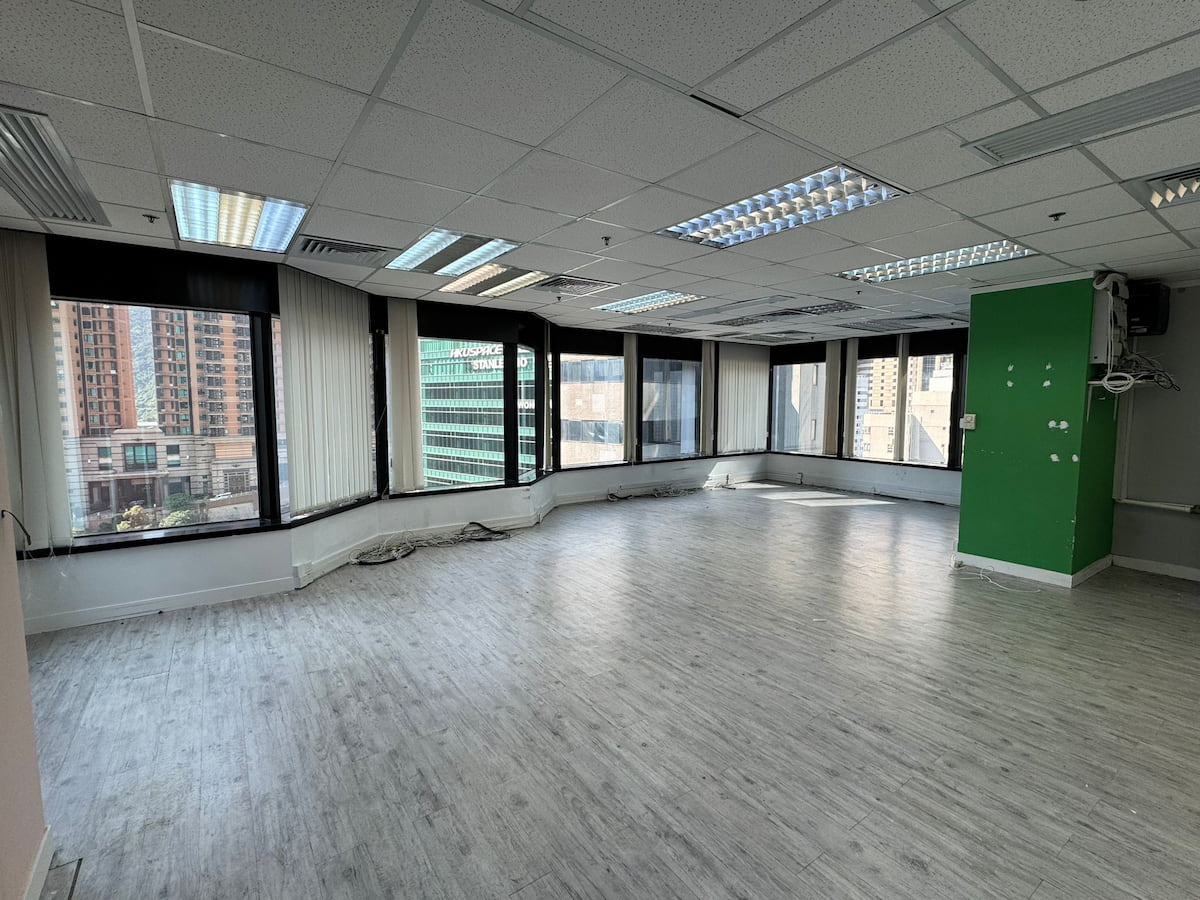 Office space on Leighton Road with large windows, light wood flooring, green accent wall, and Causeway Bay city views.