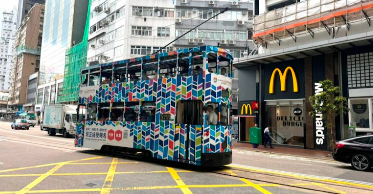 A colorful double-decker tram travels along Leighton Road past McDonald’s in busy Causeway Bay, Hong Kong.