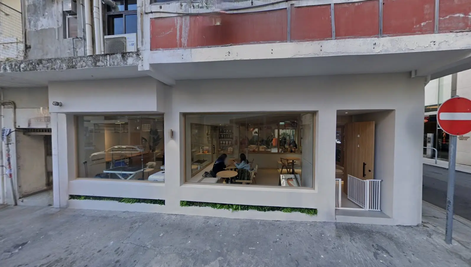 Restaurant space on Shepherd Street, Tai Hang. Modern cafe with large windows, with people seated inside at tables.