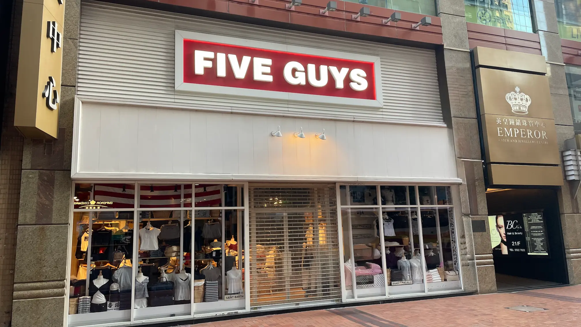 銅鑼灣舖位。羅素街Five Guys舖面,鐵閘半放下,附近店舖展示衣物。