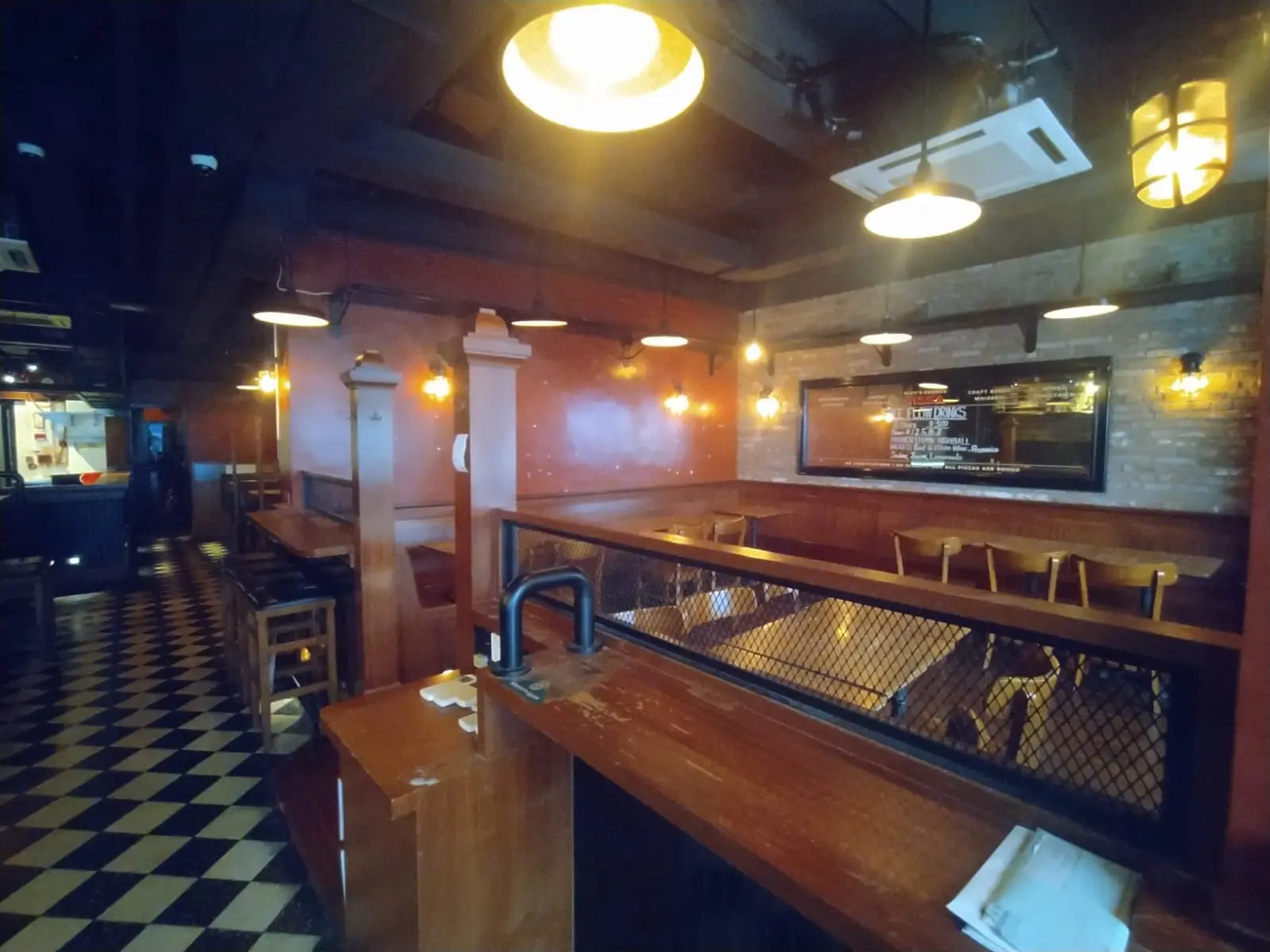 Eatery on Holland Street in Kennedy Town featuring wooden booths, checkered floor, hanging lights, and menu boards.