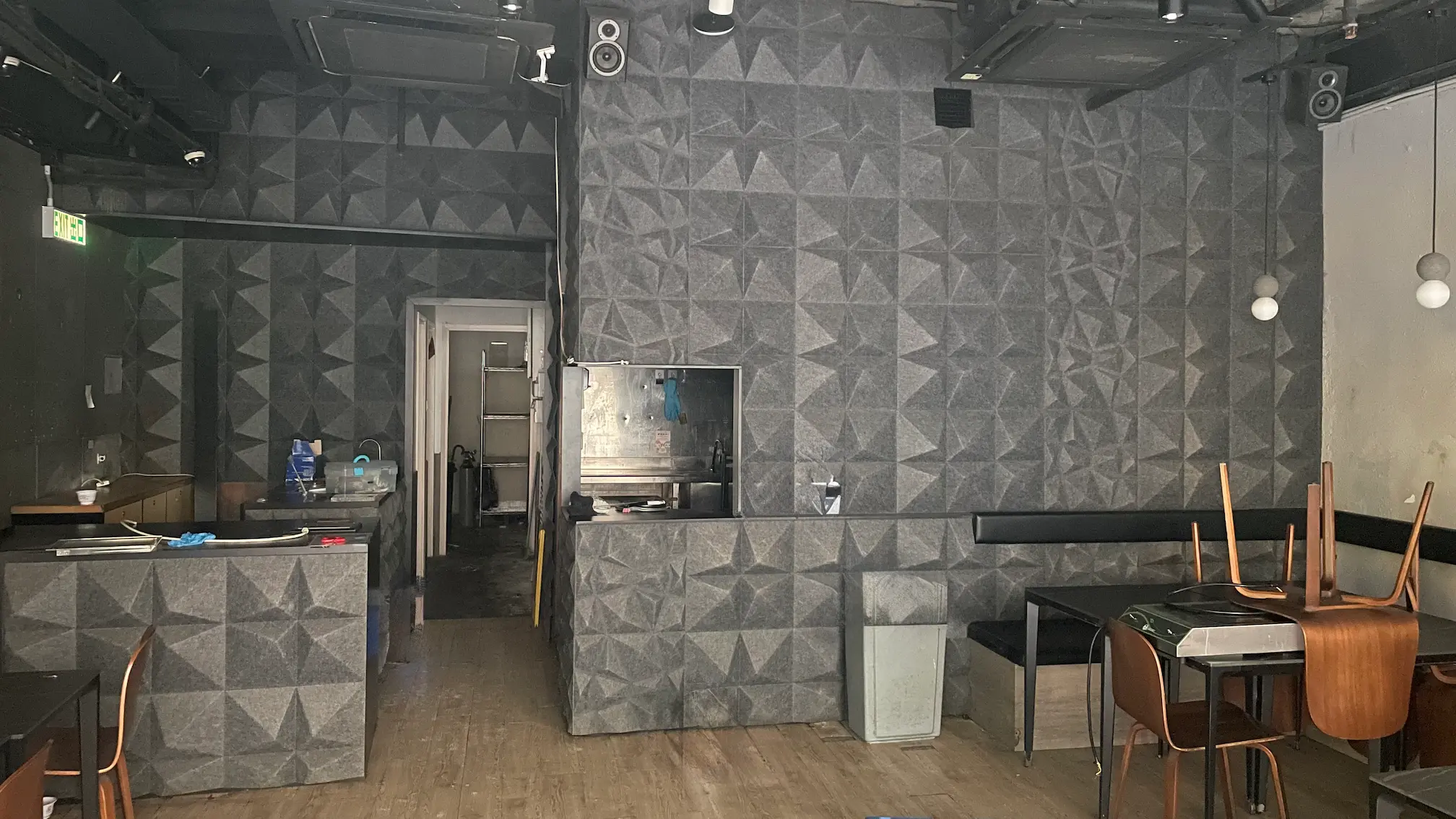 上環皇后大道中一間餐廳內部，設有灰色紋理牆身、疊放的座椅，光線昏暗。