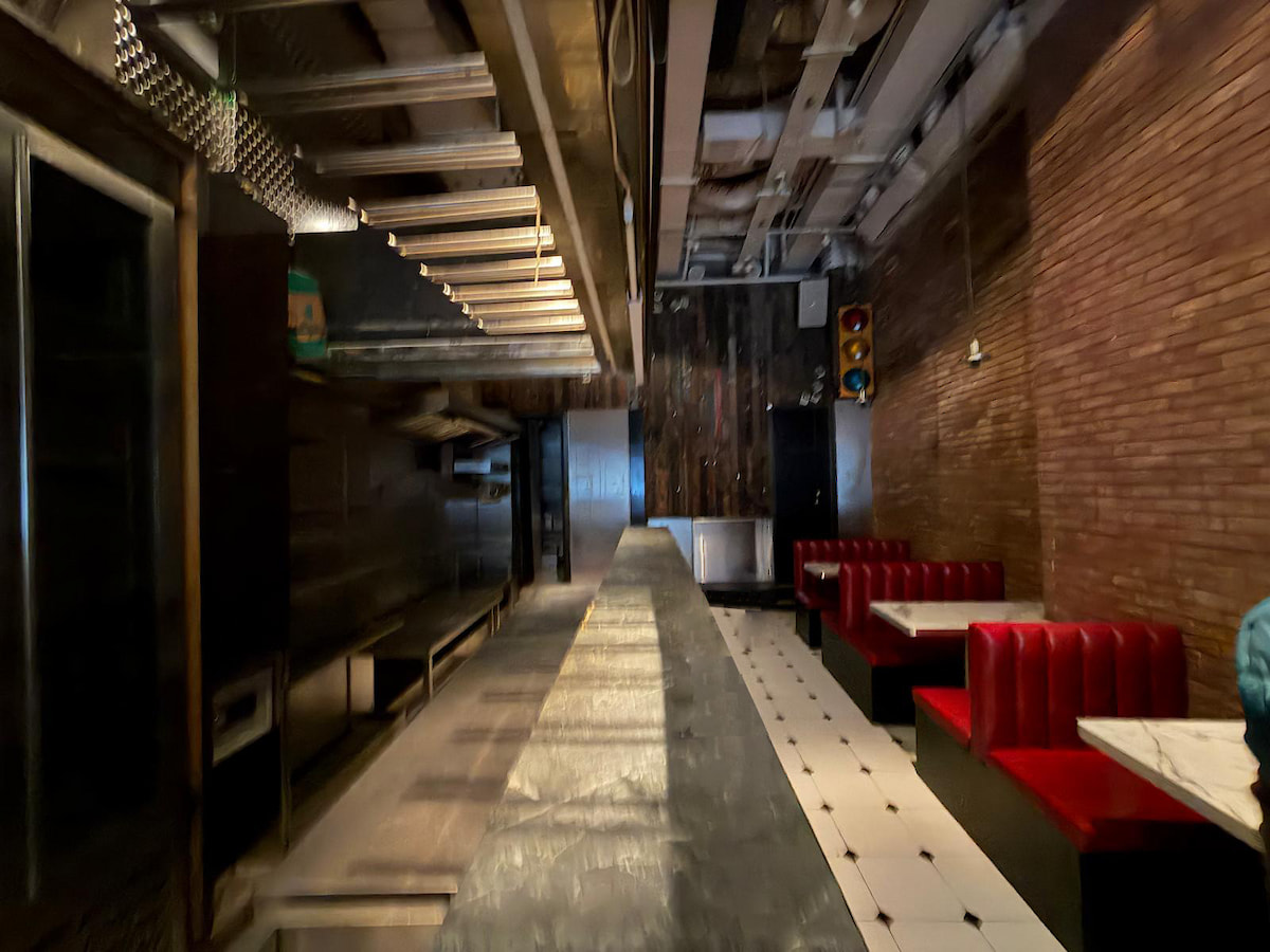 A dimly lit restaurant on Wyndham Street in Central with a long counter, red booths, and a tiled floor.