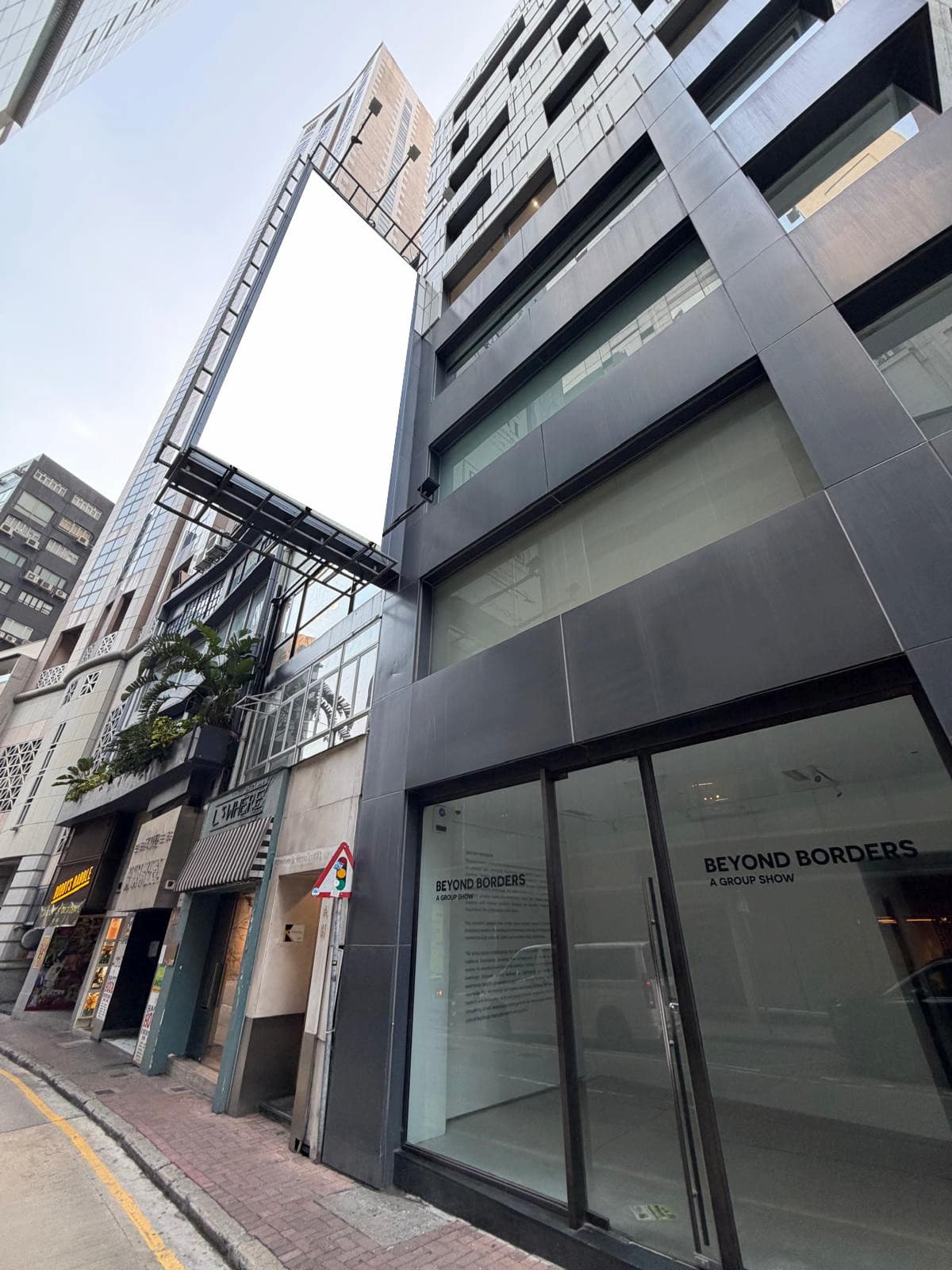 中環雲咸街一帶為玻璃及金屬建築，行人路上方設有一個空白直向廣告牌。