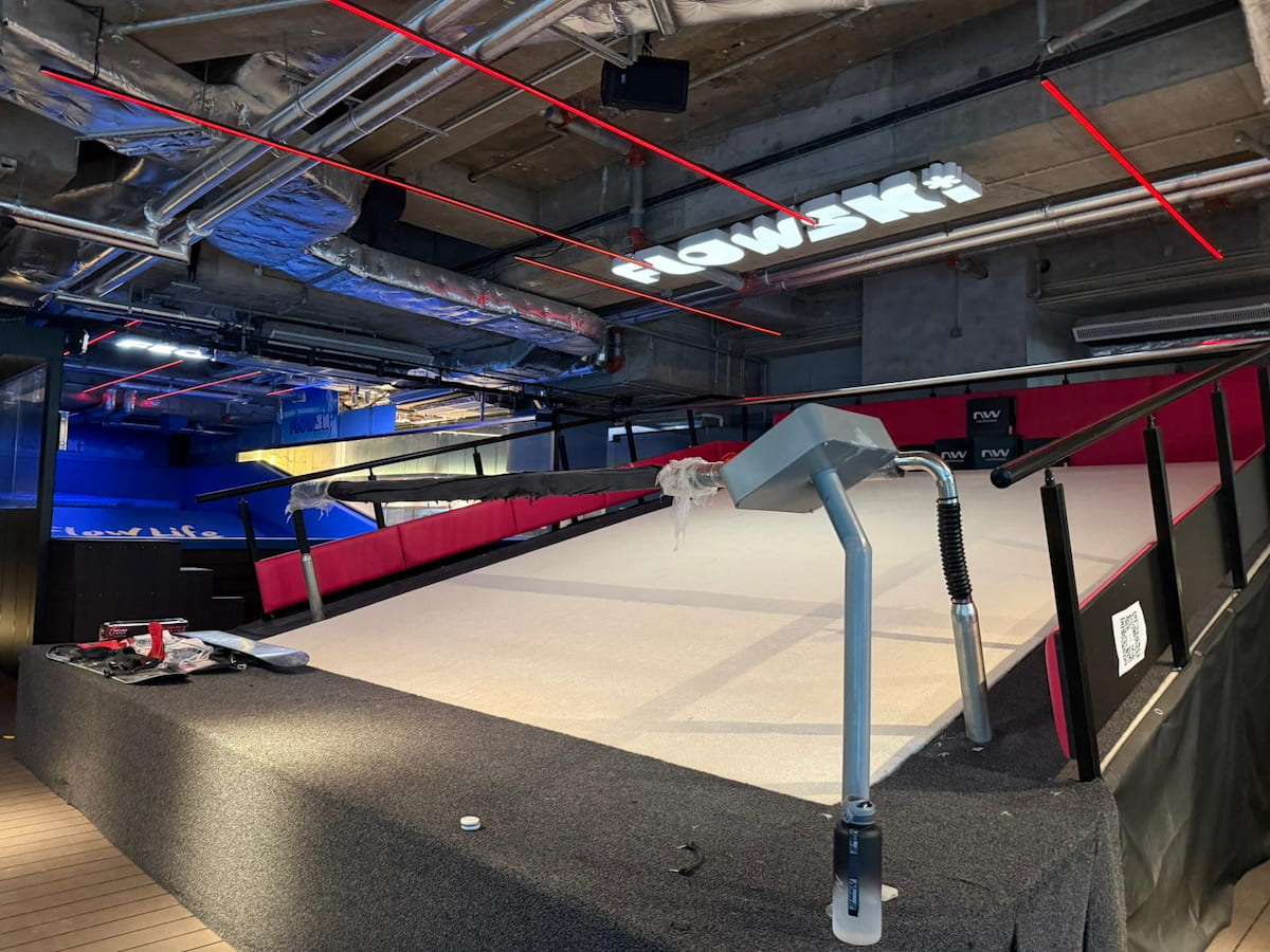 Indoor artificial ski slope with handrail, red barriers, and industrial ceiling on Yip Kan Street in Wong Chuk Hang.