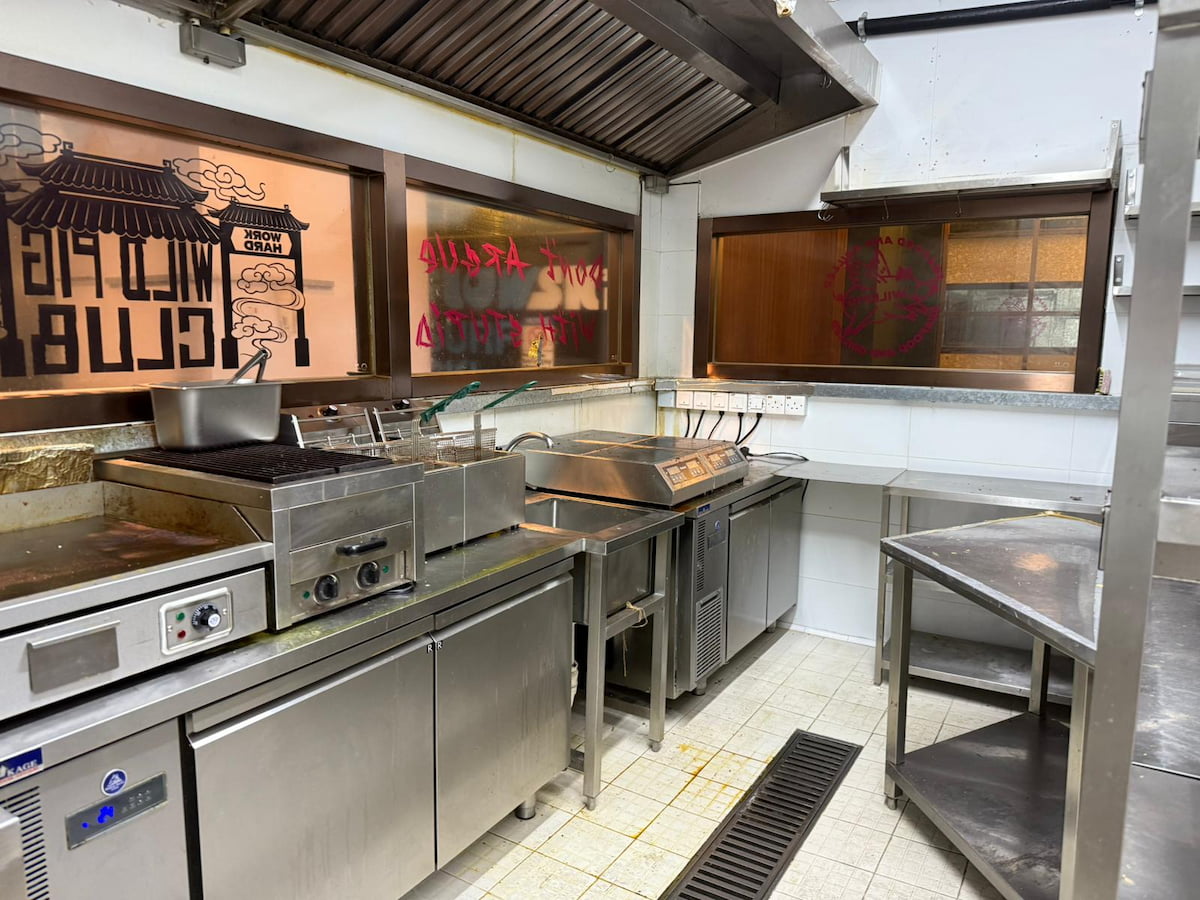 Stainless commercial kitchen on Yip Kan Street, Wong Chuk Hang, with windowed workstations and visible writing.