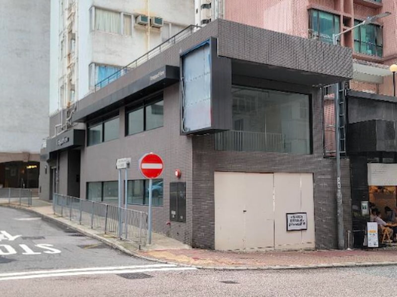 Shop on Sing Woo Road, Happy Valley. Gray two-story corner building with large windows, next to a no entry street sign.