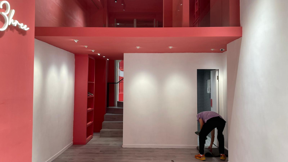 Person cleaning a white and pink room with modern design and stairs near Wellington Street.