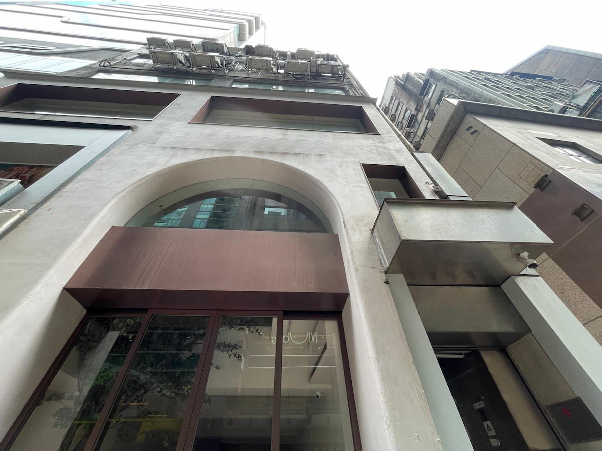 A modern multi-story building with large windows and metal accents stands on Central Wellington Street.