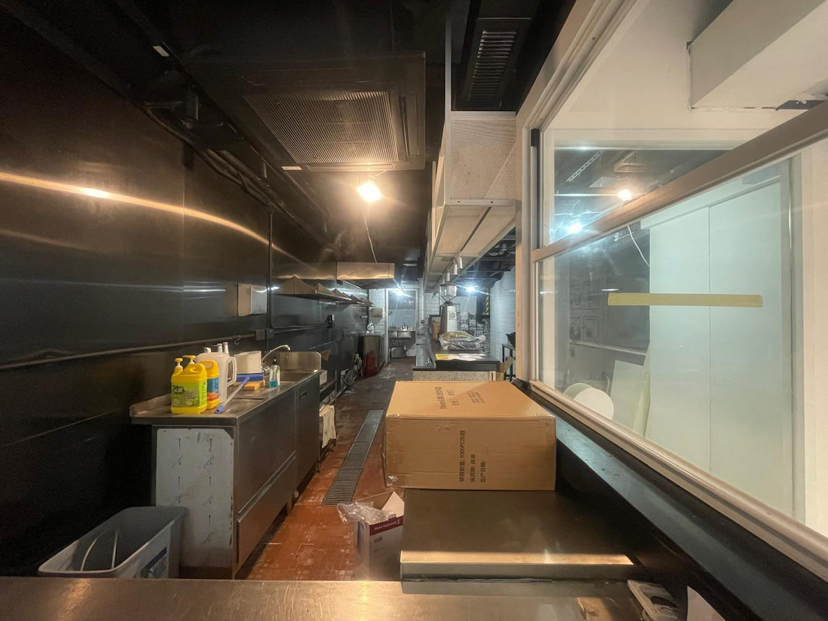 Stainless steel commercial kitchen on Hillier Street, Sheung Wan with counters, cleaning supplies, and overhead lighting.