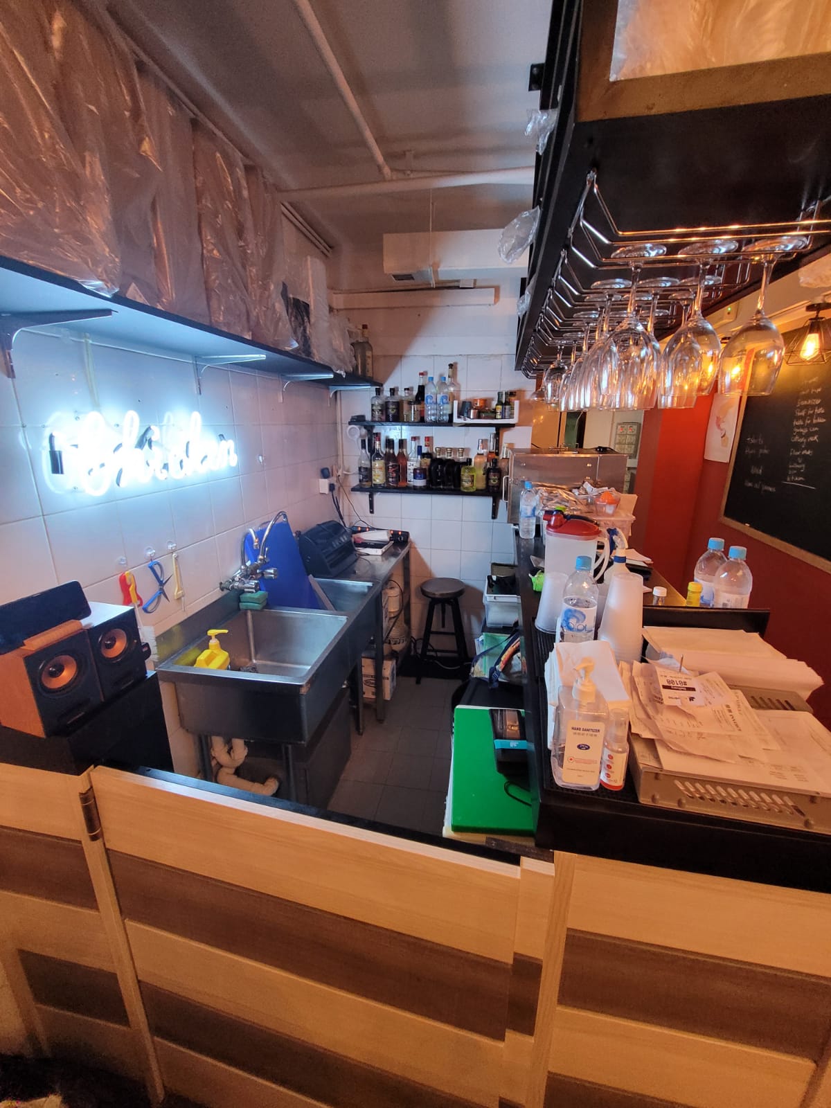 中環嘉咸街一個細小酒吧區域，設有水槽、酒瓶架、懸掛酒杯及檯面用品。
