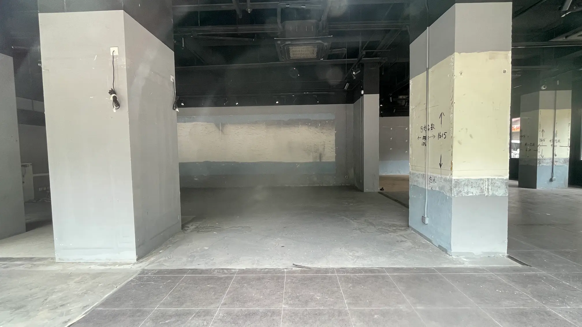 Unfinished interior on Holland Street Kennedy Town with concrete floors and exposed wiring visible on structural columns.