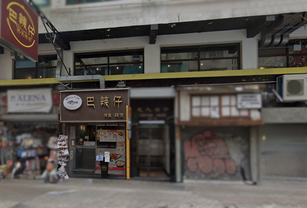 Shop on Granville Road, Tsim Sha Tsui. Street-level view of Grill Fish restaurant, beside a closed graffiti-covered entrance.