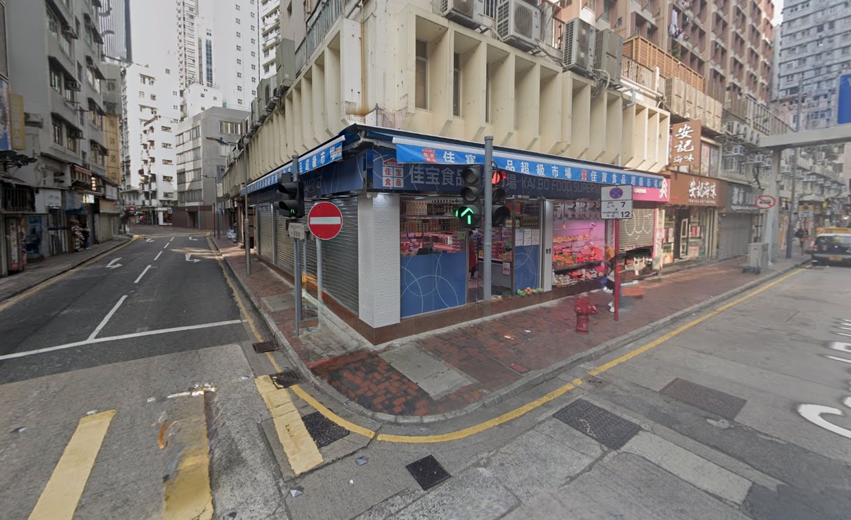 銅鑼灣舖位。堅拿道西街角,可見店舖、高樓大廈、禁止駛入標誌及綠色交通燈。