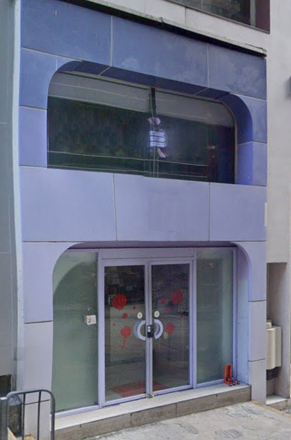 Small building with blue panels on Wellington Street, glass doors, and a bear face graphic above the entrance.
